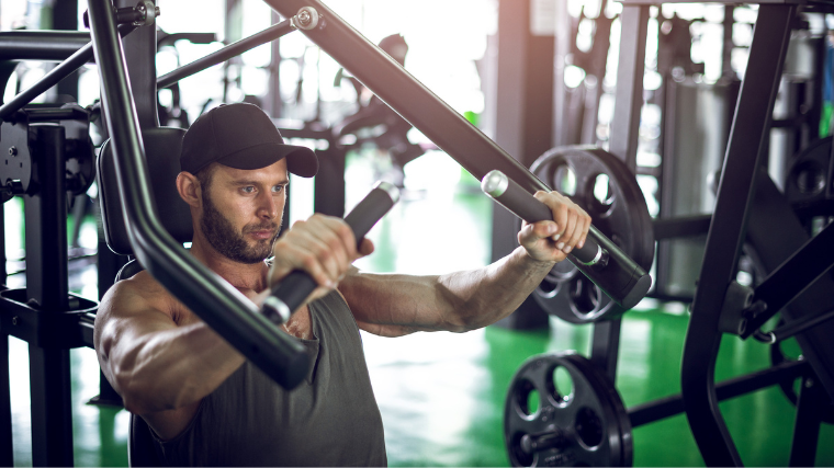 man exercises on chest press machine