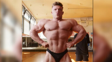A shirtless bodybuilder poses with his hands on his hips.