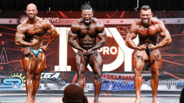 Three bodybuilders posing on a stage