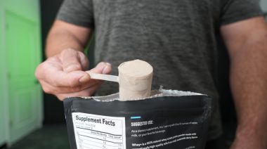 a person scooping a serving of protein powder