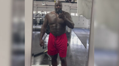 NBA star Shaq posing shirtless in the mirror.