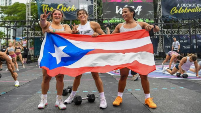 Three athletes pose with their country's flag.