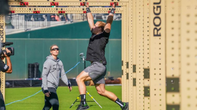 CrossFit athlete traversing across monkey bars at the 2022 Rogue Invitational.