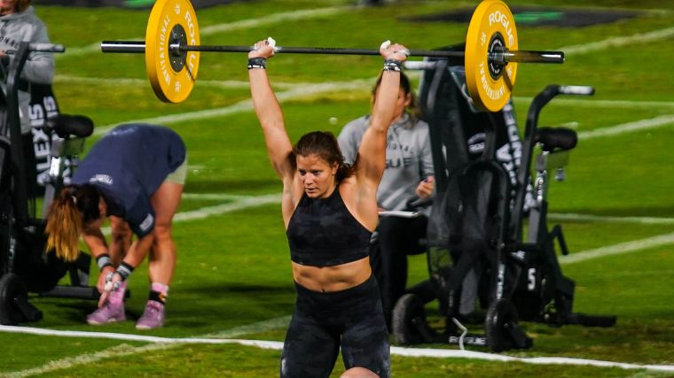 CrossFitter Laura Horvath pushing a loaded barbell overhead at the 2022 Rogue Invitational.