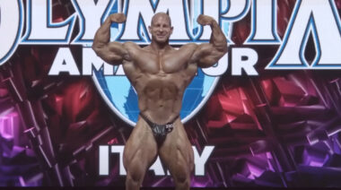 Bodybuilder Michal Krizo posing on stage.