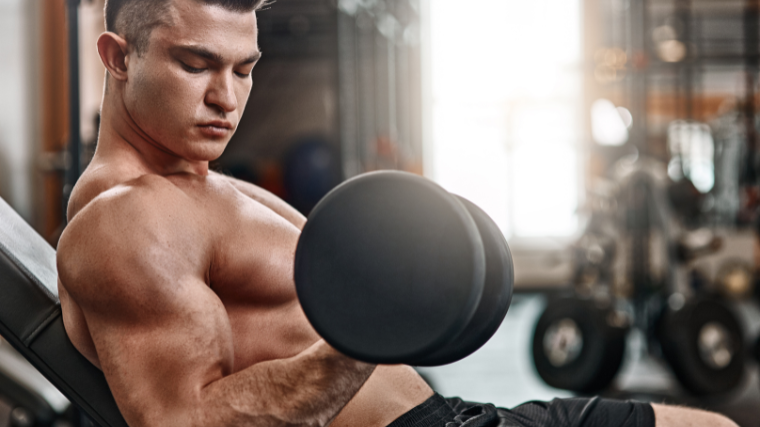 man focuses on biceps contraction during incline curl