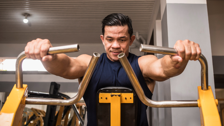 Man focuses intently on back workout with row machine