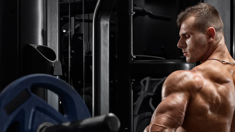 Athlete flexing gym after rowing exercise on the machine