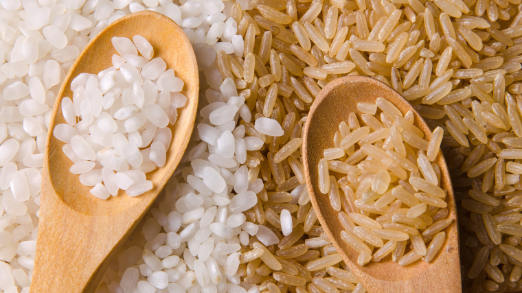 brown and white rice on spoons and in contrast