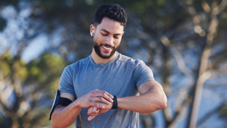 athlete outdoors running and tracking time on watch