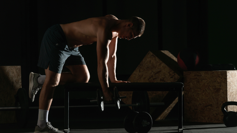 athlete in gym setting up form on weight bench for exercise