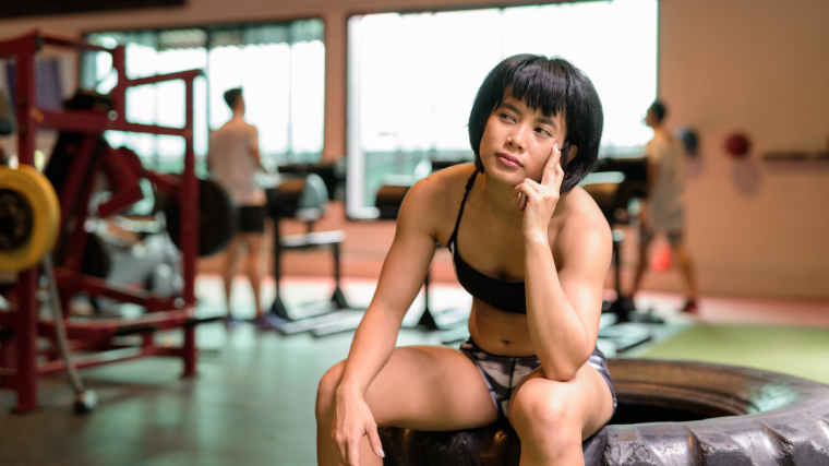 athlete in gym sitting and thinking