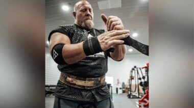 Strongman Nick Best wraps his wrist with wrist wraps.