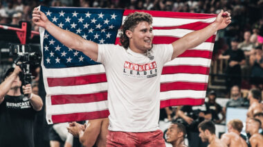 CrossFit star Justin Medeiros poses with the American flag.