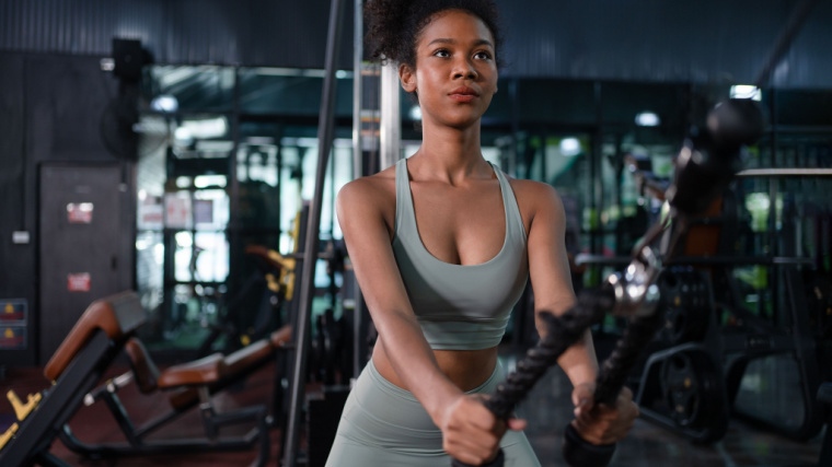 Woman performs cable ab exercise with rope