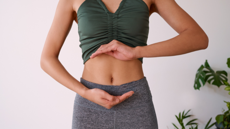 woman cradles toned stomach during yoga