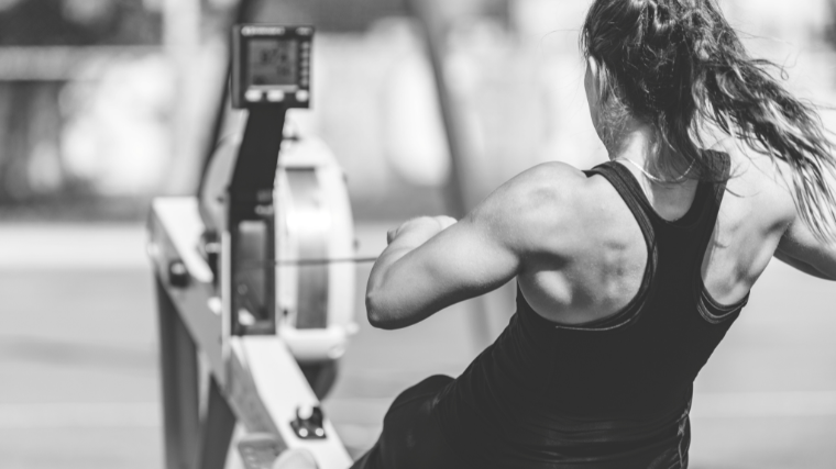 Athlete rowing powerfully on a rowing machine.