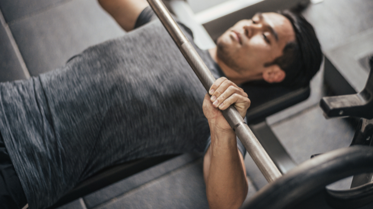 Athlete performing a chest press using a suicide grip.