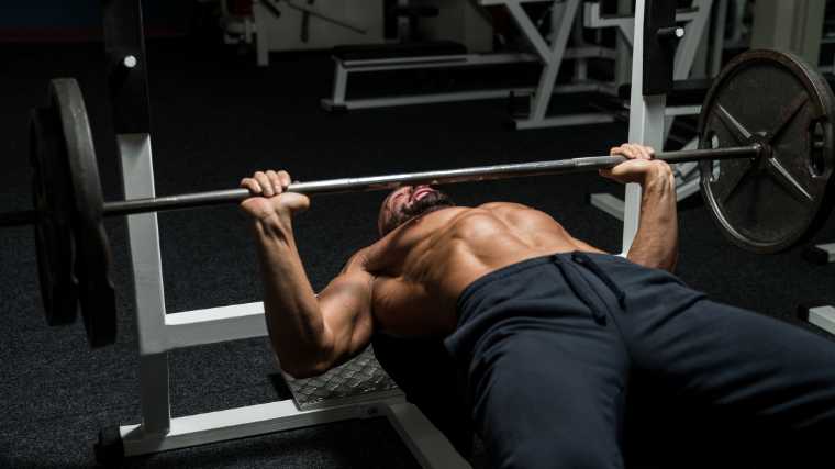 Athlete performing wide gripped bench press using the suicide grip