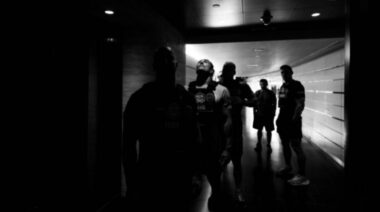 A group of athletes waits in a hallway before embarking on a long stair climb.