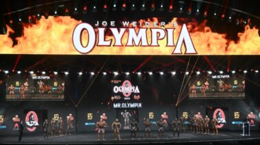 A wide-angle shot of a yellow and orange stage for the 2022 Mr. Olympia competition in Las Vegas, NV.