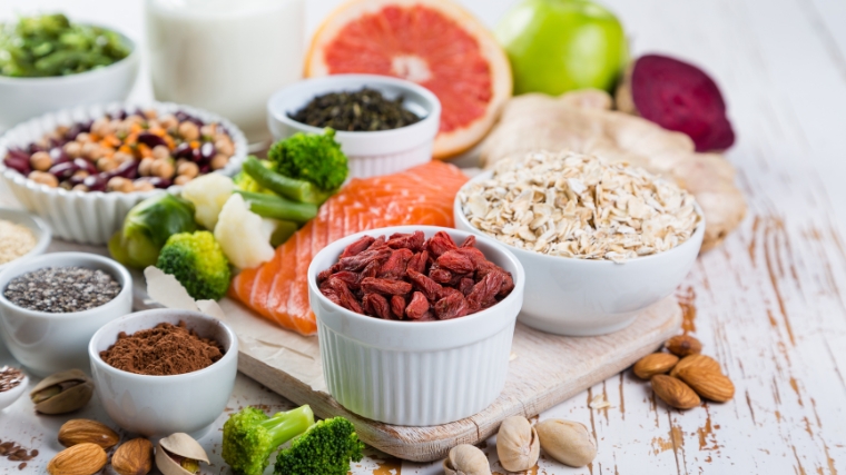 A display of oats in a small bowl, brussels sprouts, broccoli and lentils in a bowl