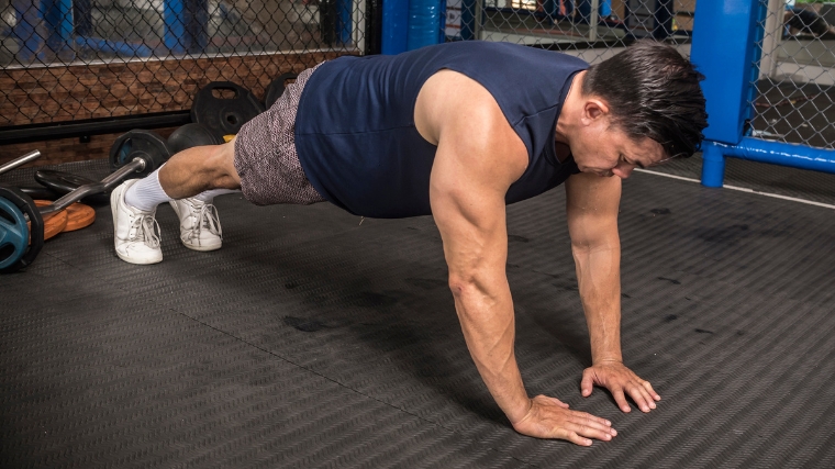 A person doing a push-up in the gym.