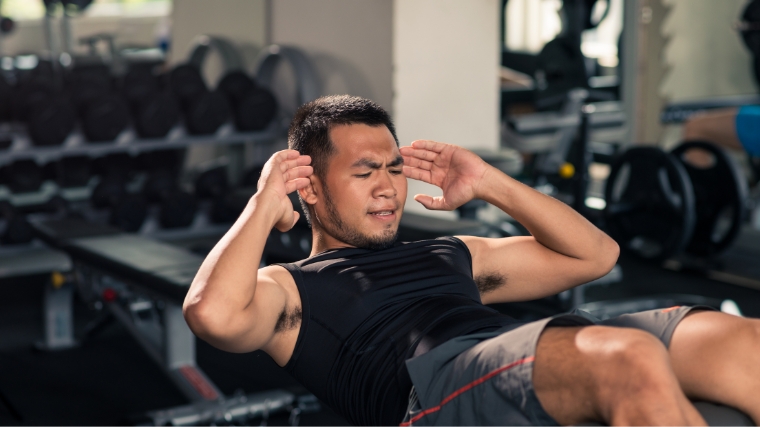 Athlete making effort to do last situp