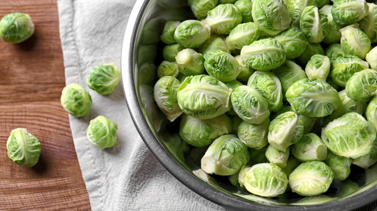 Brussel sprouts in a metal brown on a white napkin.