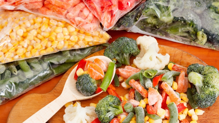 Frozen vegetables in freezer bags and on cutting board