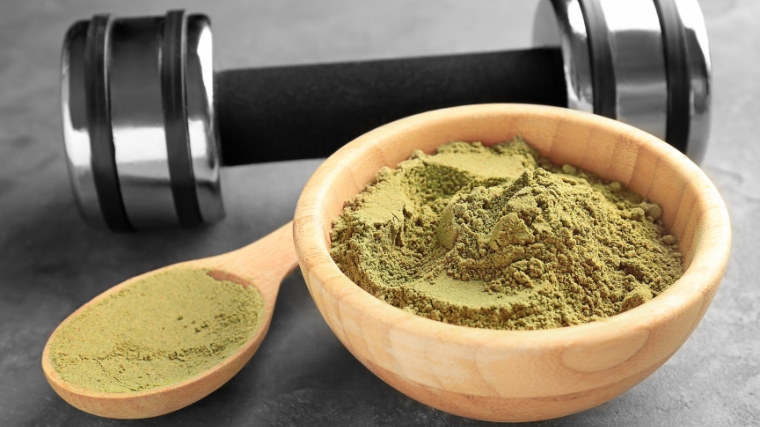 Hemp protein powder in a wooden spoon and bowl.