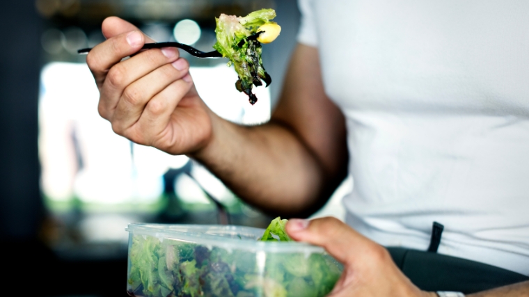 Person eating green vegetables