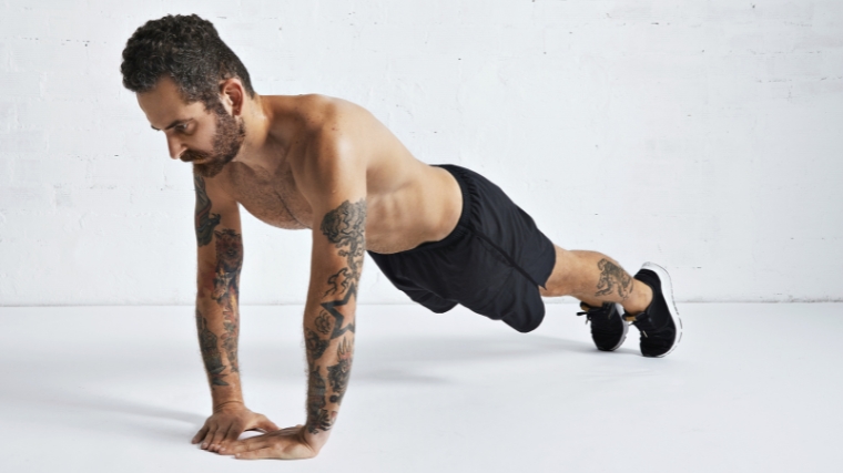 Ripped athlete in starting position for a diamond push-up.