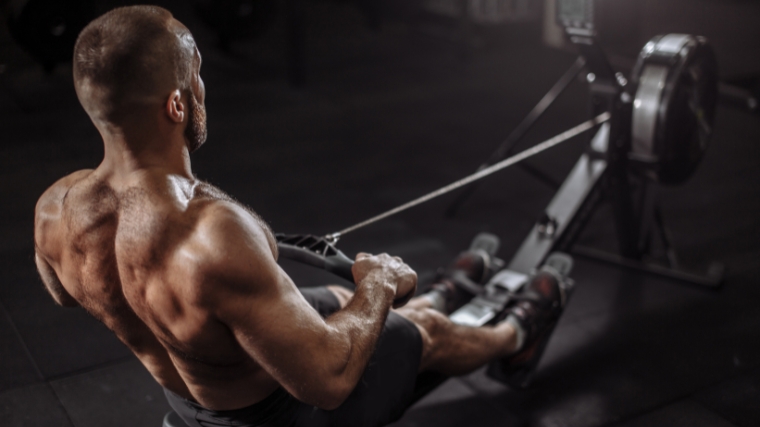 Well-built person warming up with rowing machine