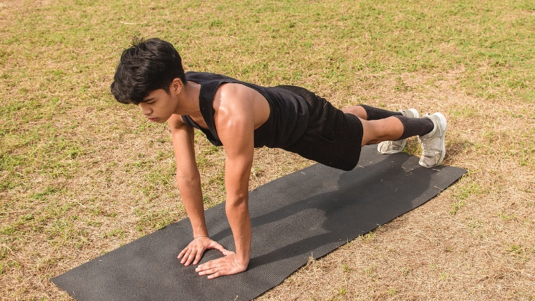 Young person performing a diamond push-up.