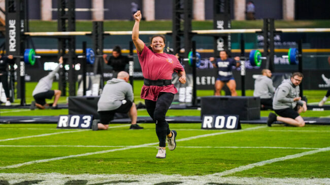 Laura Horvath raises her hand up in victory and smiles.