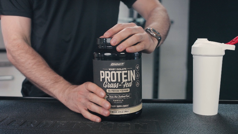 A person opening a container of Onnit Whey Isolate