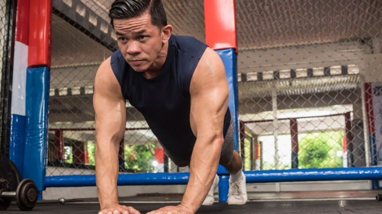 A person performs diamond push-ups in the gym.