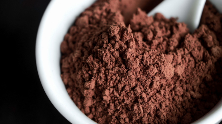 A small bowl of cocoa powder sits on a table.