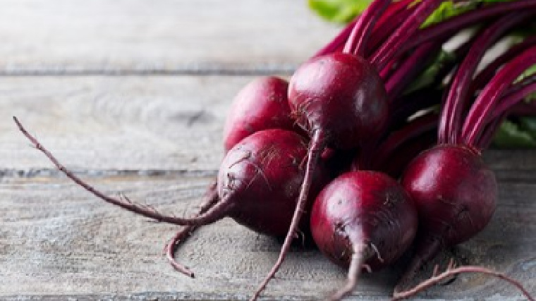 A group of beets sit on a table.