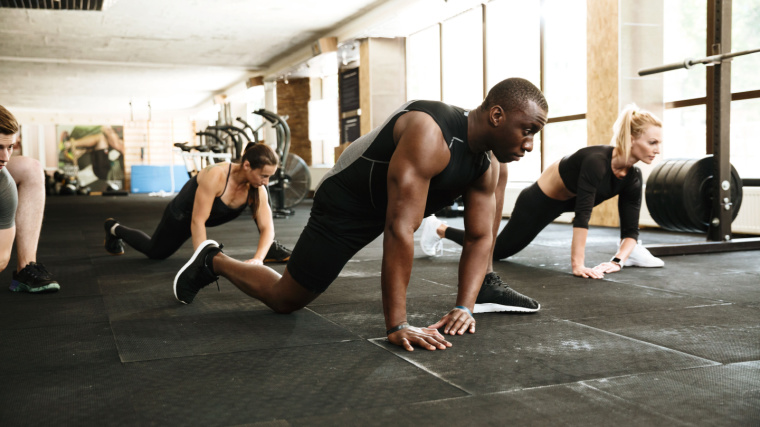 People perform a CrossFit warm-up in the gym.