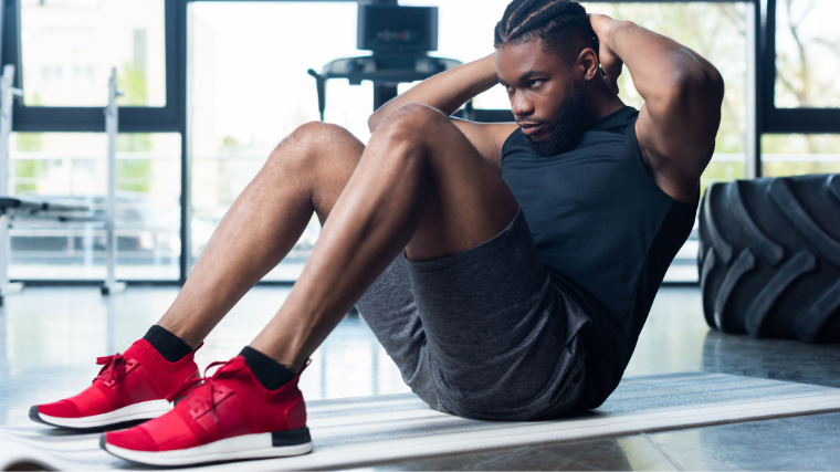 Man performs seated sit-up exercise on mat