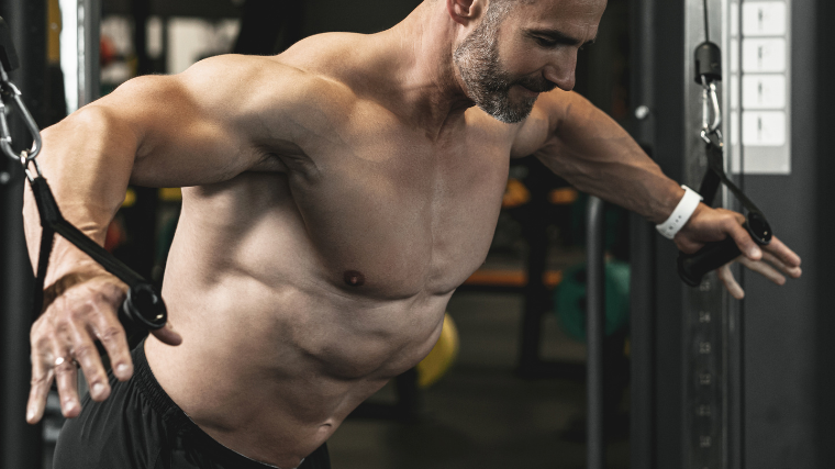 Bodybuilder focuses during cable chest flye exercise