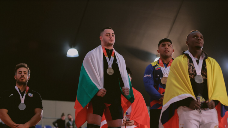 Karlos Nasar accepts his clean & jerk gold medal