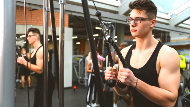 Young bodybuilder working out with cables