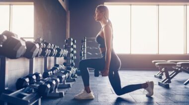 A person doing a split squat inside the gym.