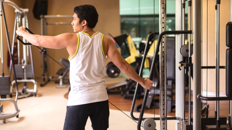 A person performing a lateral cable raise.