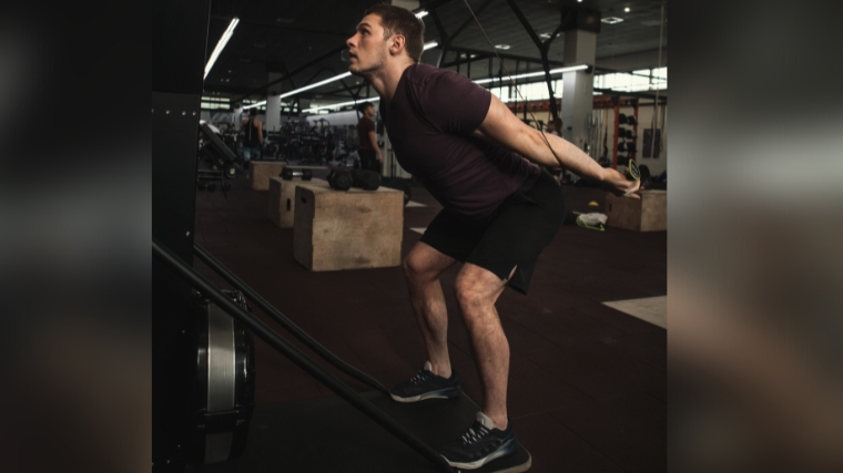 A person using a ski erg machine in the gym.