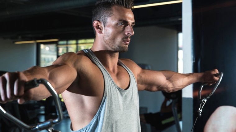 A person working out with cables - x lateral raise.