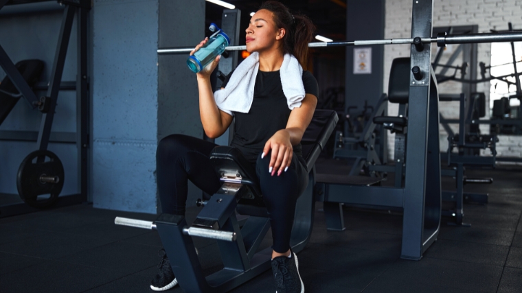 A person drinking water before working out at the gym.